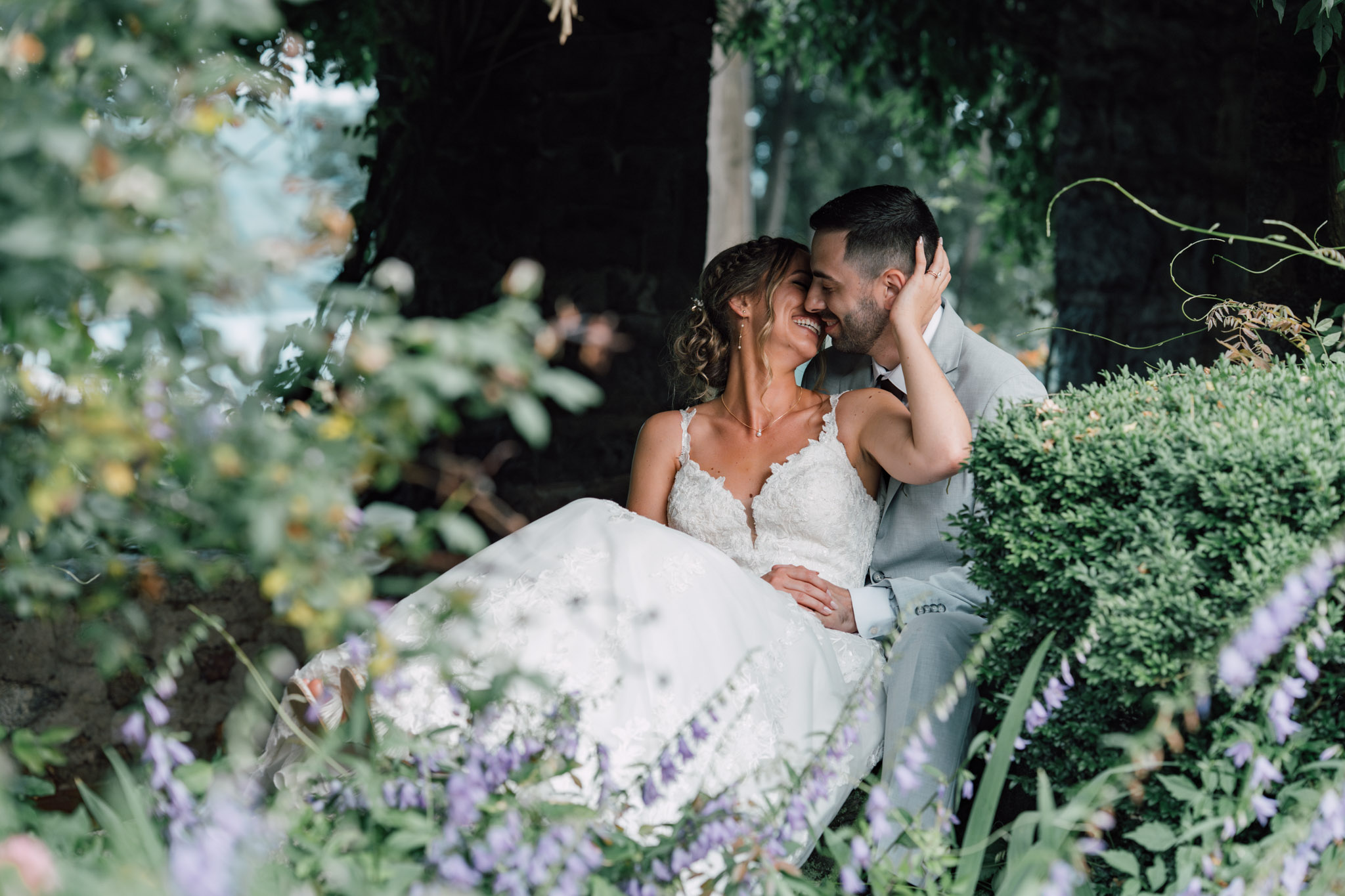 Newlyweds leaning together on a garden bench at Saint Clements Castle, Portland, Connecticut
