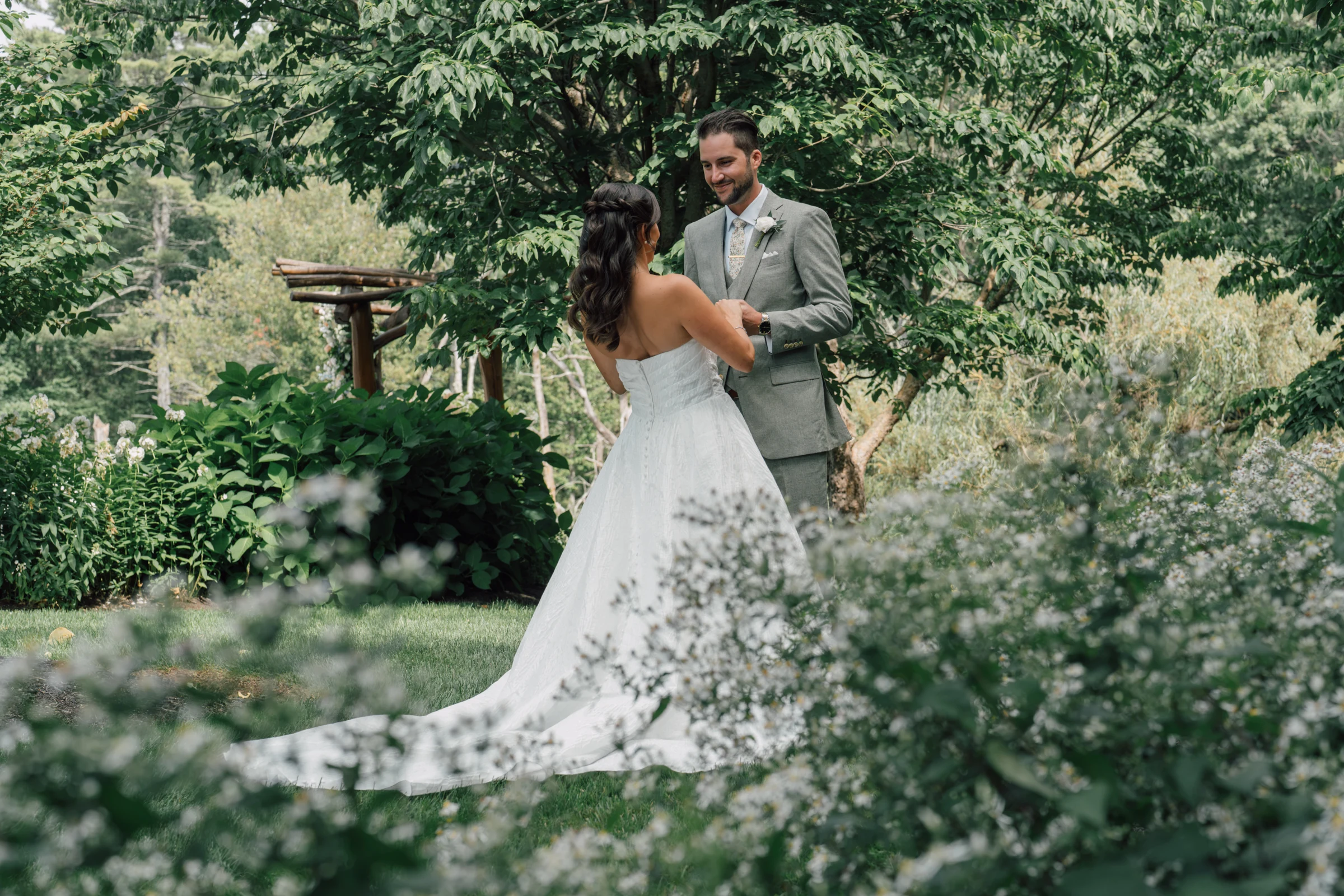 A couple holding hands during their first look in a garden at Harrington Farm, Princeton, Massachusetts