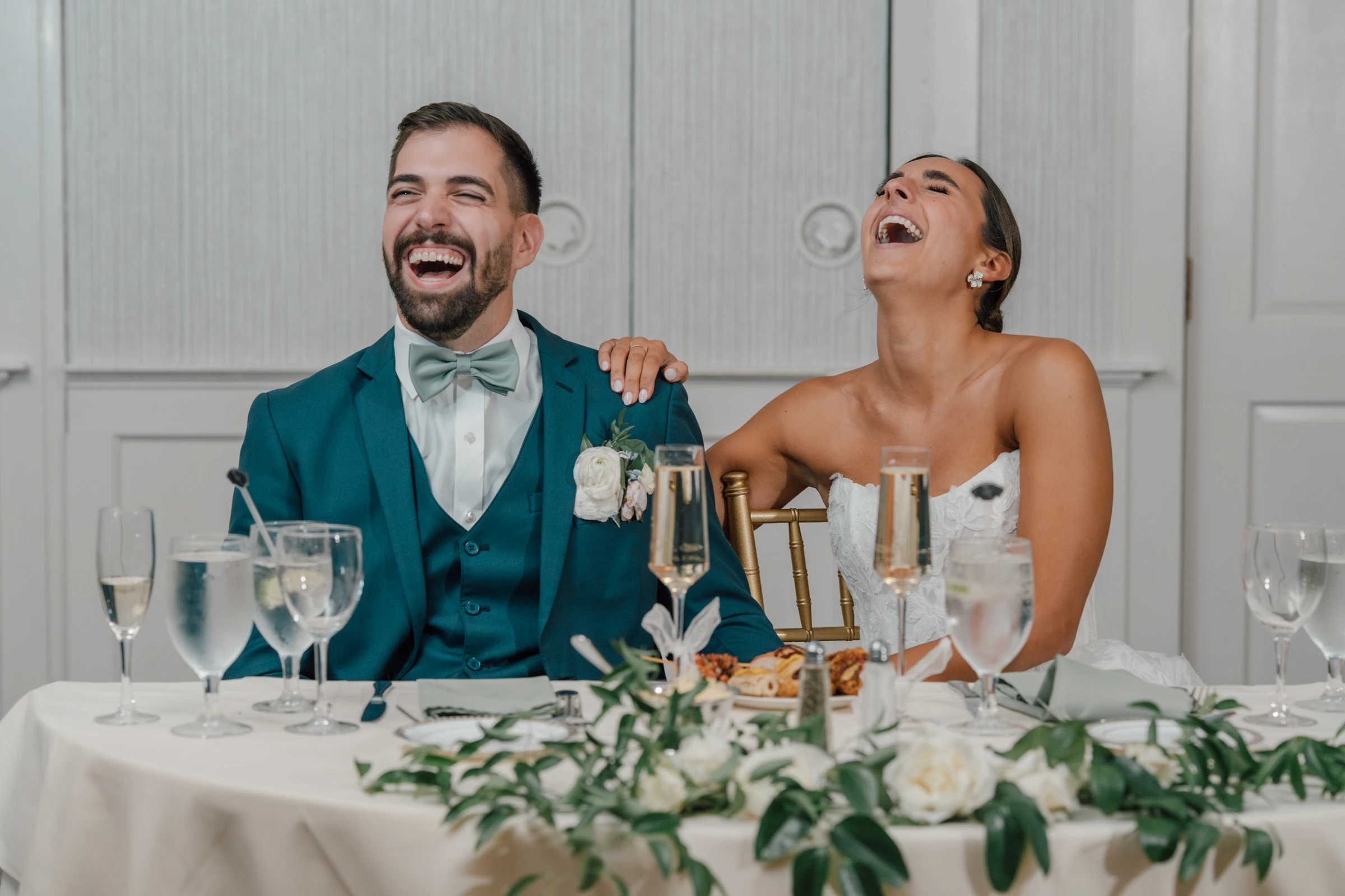 Newlyweds sharing a joyful laugh during their reception at Prince Edward Ballroom at Saint Clements Castle, Portland, Connecticut