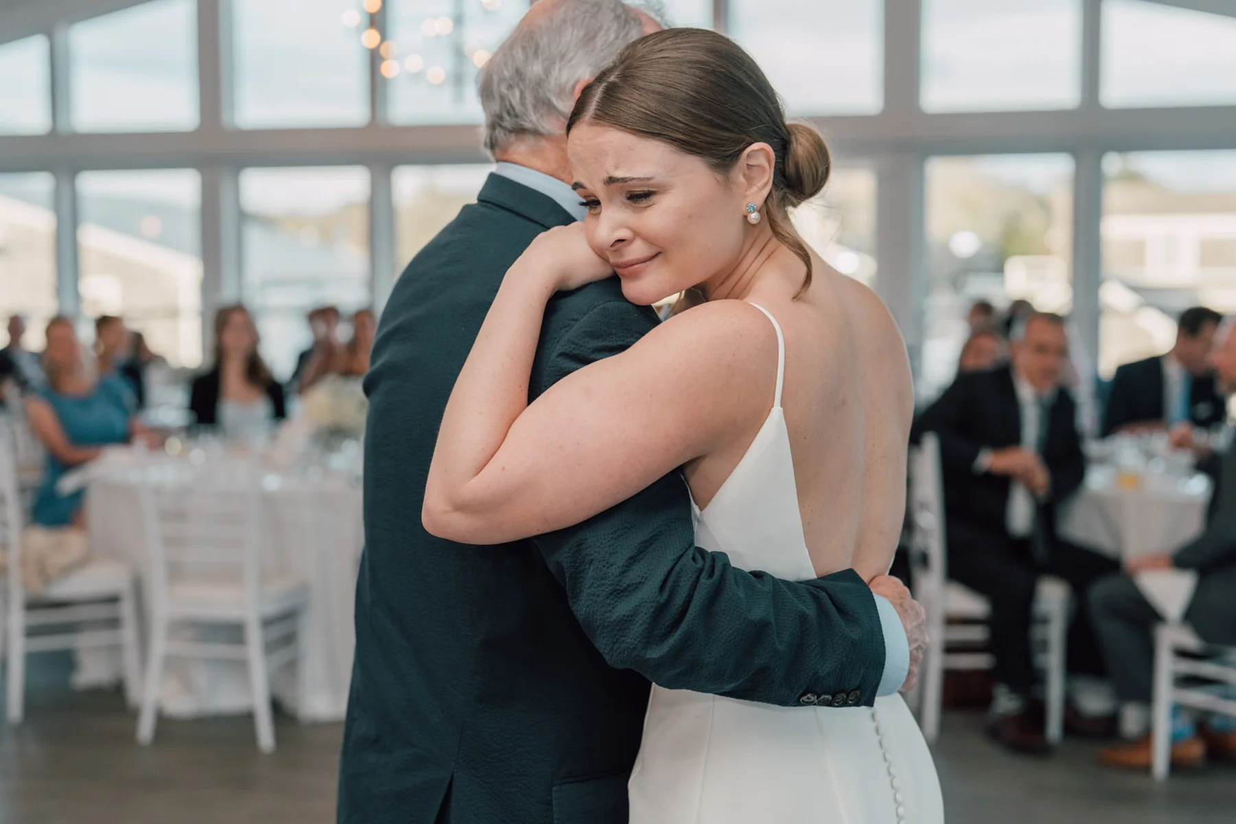A bride embracing a loved one on the dance floor at Ocean Room at Wychmere Beach Club, Harwich Port, Massachusetts