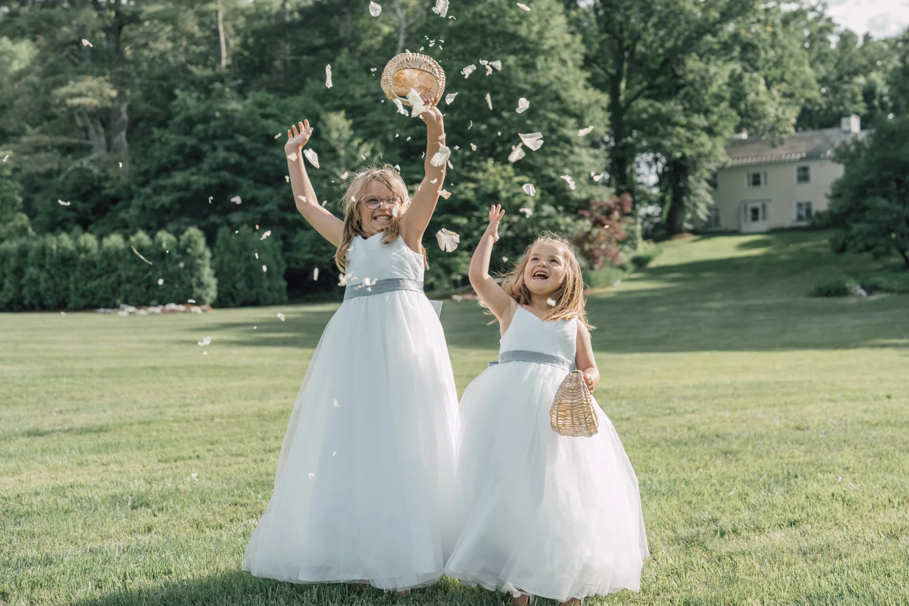 Flower girls lifting their baskets in celebration at Oakholm Farm Estate, Brookfield, Massachusetts