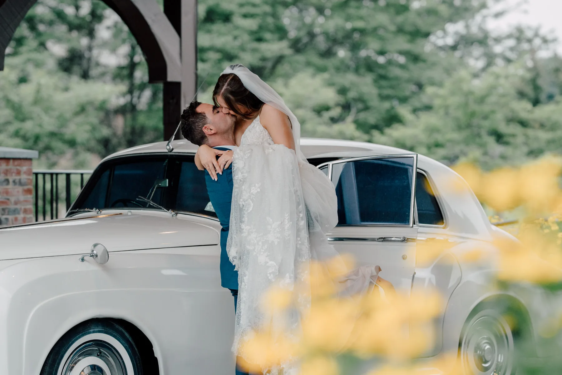 Newlyweds beside a vintage white car