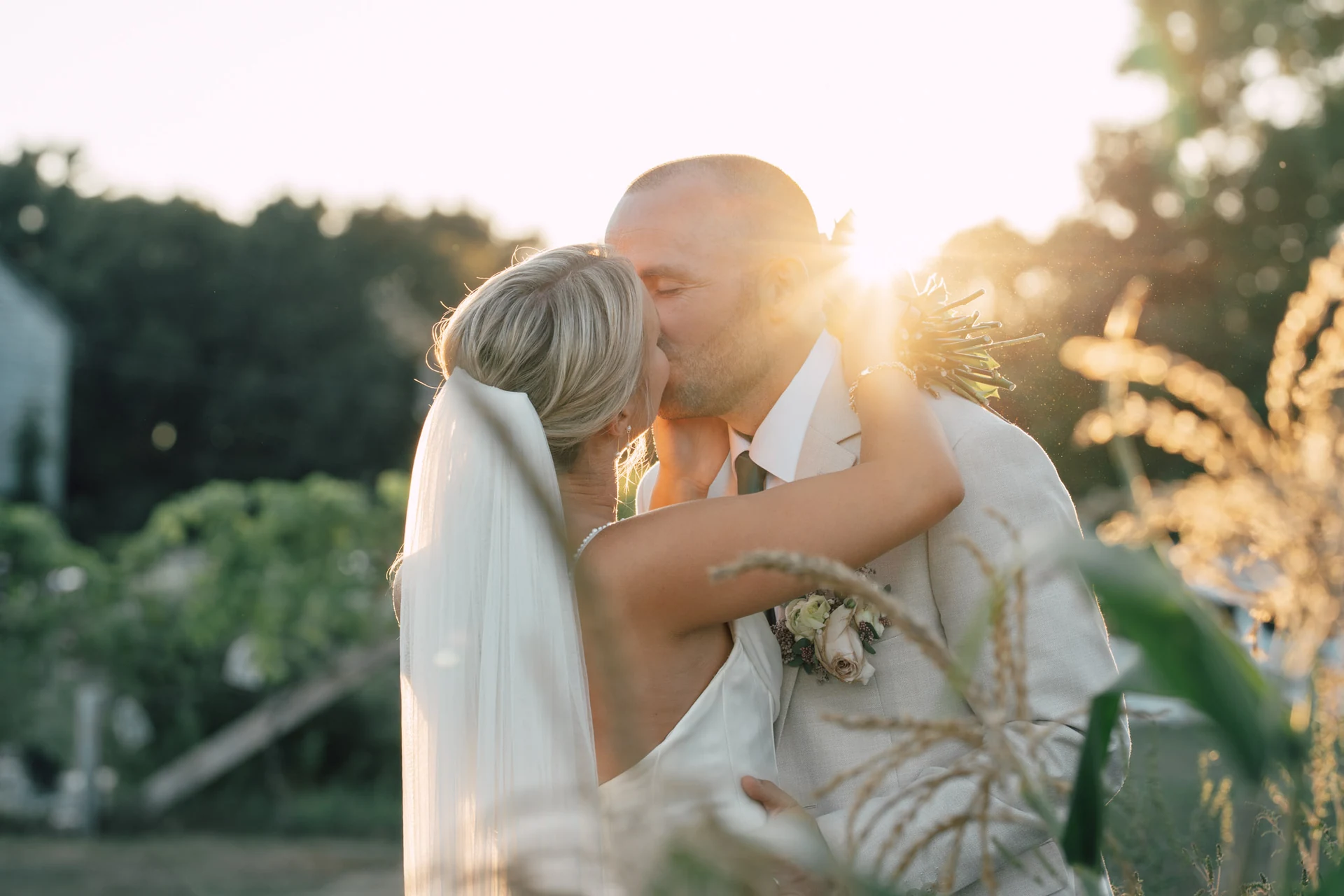 Newlyweds kissing in warm sunlight at The Barn at Bradstreet Farm, Rowley, Massachusetts